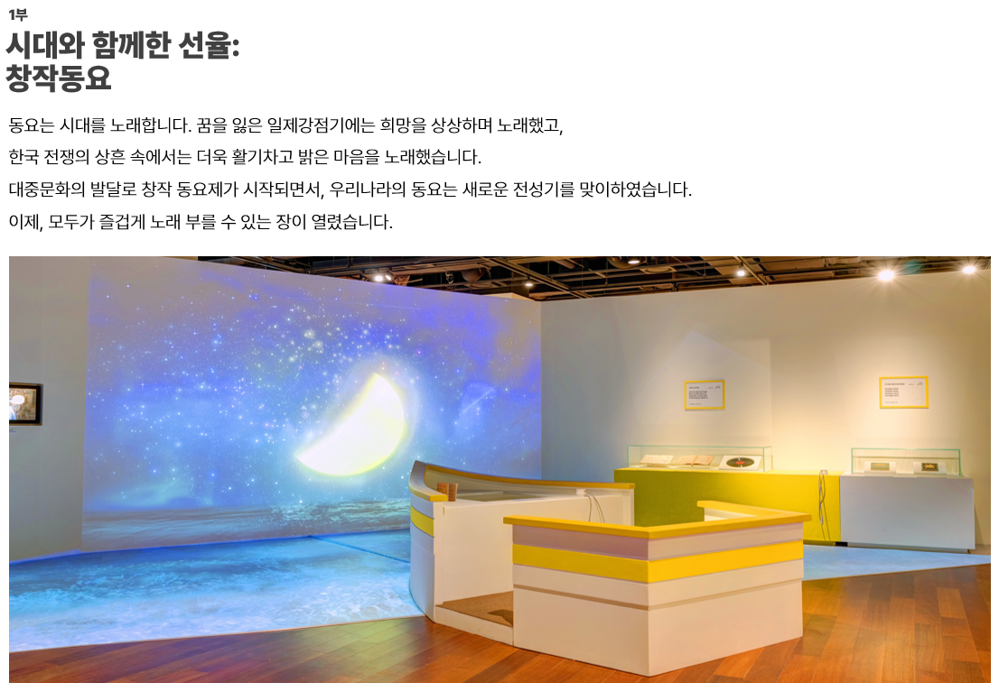 이미지: 1부. 시대와 함께한 선율:창작동요-동요는 시대를 노래합니다. 꿈을 잃은 일제강점기에는 희망을 상상하며 노래했고, 한국 전쟁의 상흔 속에서는 더욱 활기차고 밝은 마음을 노래했습니다. 대중문화의 발달로 창작 동요제가 시작되면서, 우리나라의 동요는 새로운 전성기를 맞이하였습니다. 이제, 모두가 즐겁게 노래 부를 수 있는 장이 열렸습니다.  이미지: 파란마음 하얀마음 1부 전시관 전경